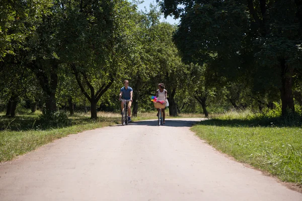 Unga multietniskt par att ha en cykel rida i naturen — Stockfoto