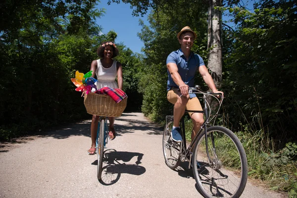 Jeune couple multiethnique faisant une balade à vélo dans la nature — Photo