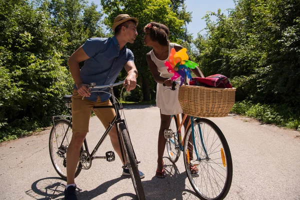 Joven pareja multiétnica teniendo un paseo en bicicleta en la naturaleza —  Fotos de Stock