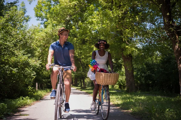 Jeune couple multiethnique faisant une balade à vélo dans la nature — Photo