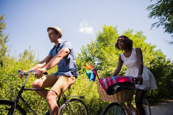 Jeune couple multiethnique faisant une balade à vélo dans la nature — Photo