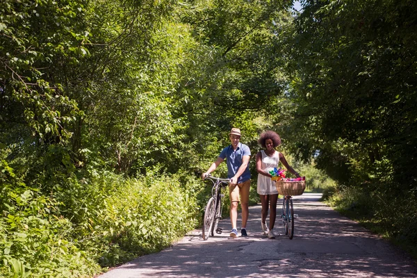 Unga multietniskt par att ha en cykel rida i naturen — Stockfoto