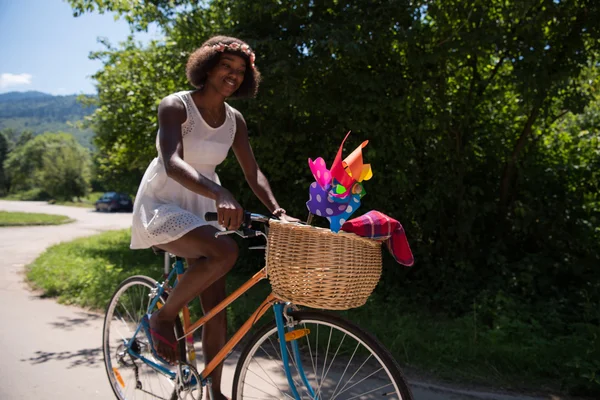 Bonita jovem afro-americana mulher montando uma bicicleta — Fotografia de Stock