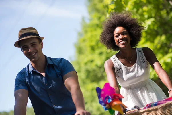 Joven pareja multiétnica teniendo un paseo en bicicleta en la naturaleza — Foto de Stock