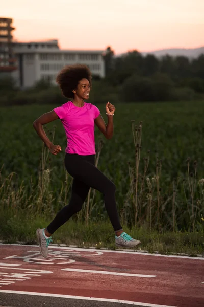 Young African American woman jogging outdoors — Stock Photo, Image