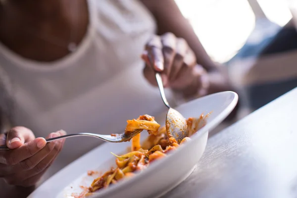 Seorang wanita muda Afrika-Amerika makan pasta — Stok Foto