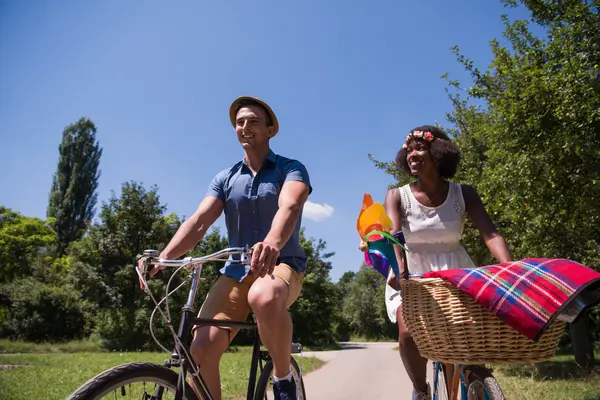 Giovane coppia multietnica che fa un giro in bicicletta nella natura — Foto Stock