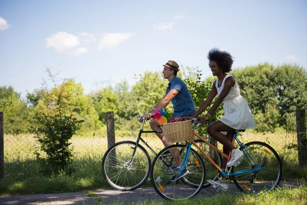 自転車を持っている若い民族カップルが自然に乗る — ストック写真