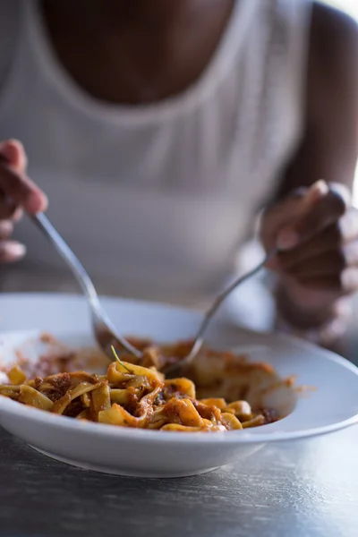 Seorang wanita muda Afrika-Amerika makan pasta — Stok Foto