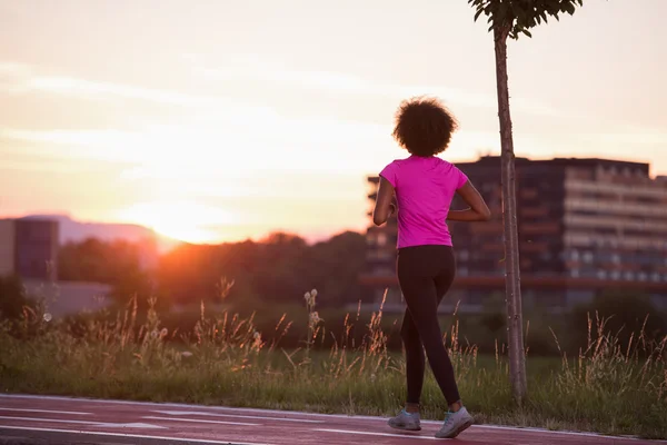 A young African American woman jogging outdoors — Stock Photo, Image