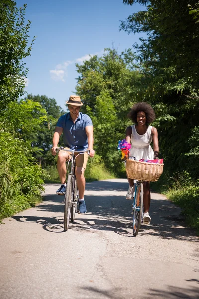 Νεαρό ζευγάρι πολυεθνική έχοντας ένα ποδήλατο βόλτα στη φύση — Φωτογραφία Αρχείου