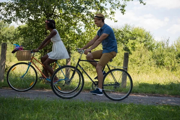 Jovem casal multiétnico ter um passeio de bicicleta na natureza — Fotografia de Stock