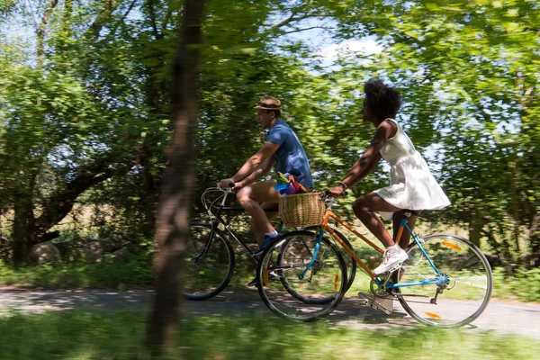 Jovem casal multiétnico ter um passeio de bicicleta na natureza — Fotografia de Stock