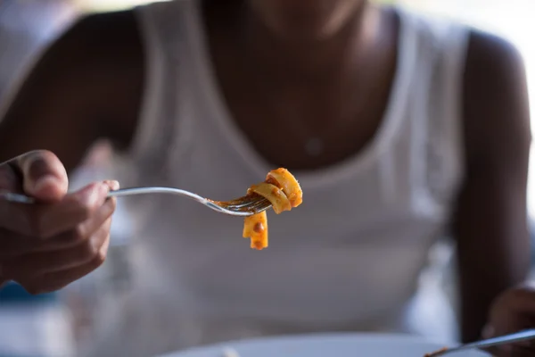 Seorang wanita muda Afrika-Amerika makan pasta — Stok Foto