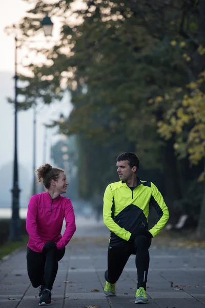 Un jeune couple s'échauffe avant de faire du jogging — Photo