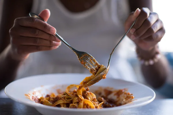 Seorang wanita muda Afrika-Amerika makan pasta — Stok Foto