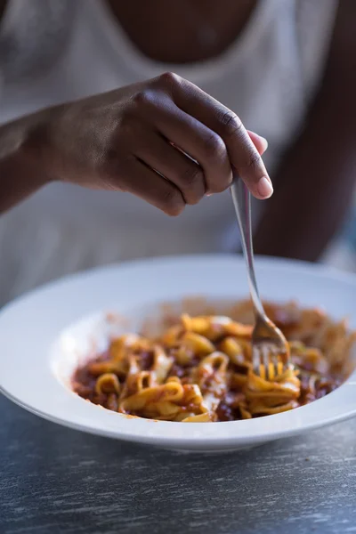 Seorang wanita muda Afrika-Amerika makan pasta — Stok Foto