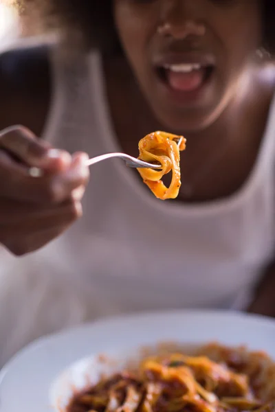 Молодая афроамериканка ест пасту — стоковое фото