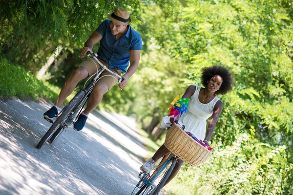 Joven pareja multiétnica teniendo un paseo en bicicleta en la naturaleza — Foto de Stock