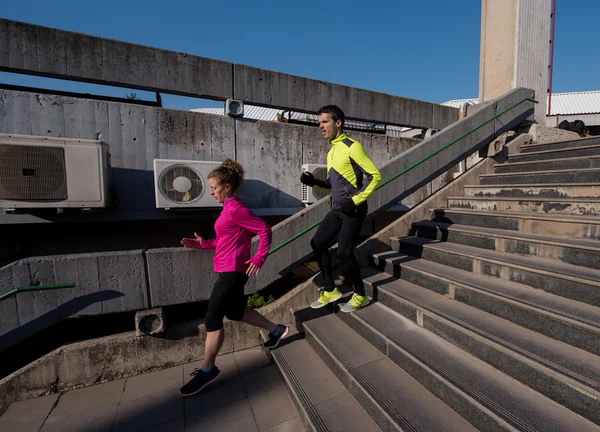 Mladý pár zaběhat na schodech — Stock fotografie