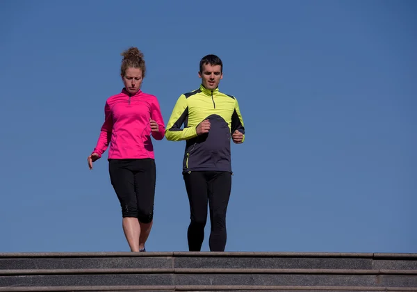 Giovane coppia jogging su gradini — Foto Stock