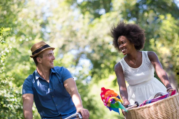 Jovem casal multiétnico ter um passeio de bicicleta na natureza — Fotografia de Stock