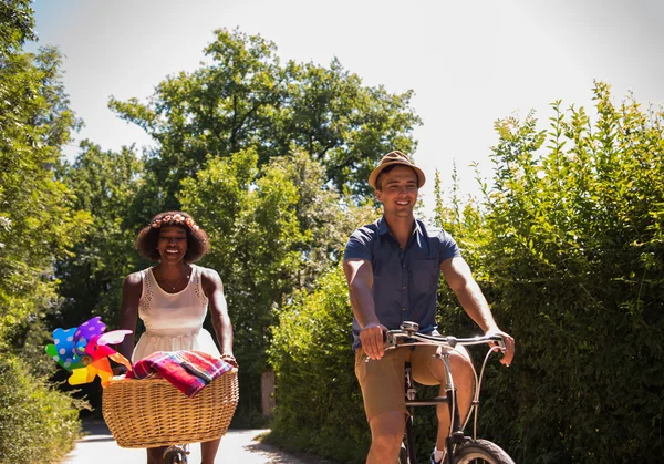 Молода багатоетнічна пара катається на велосипеді в природі — стокове фото