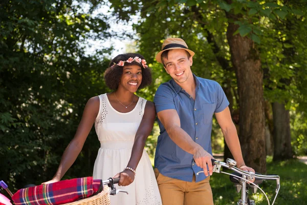 Jovem casal multiétnico ter um passeio de bicicleta na natureza — Fotografia de Stock