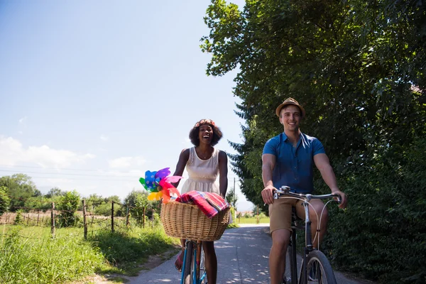 Jeune couple multiethnique faisant une balade à vélo dans la nature — Photo