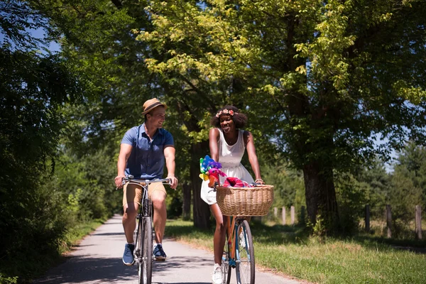 Jovem casal multiétnico ter um passeio de bicicleta na natureza — Fotografia de Stock