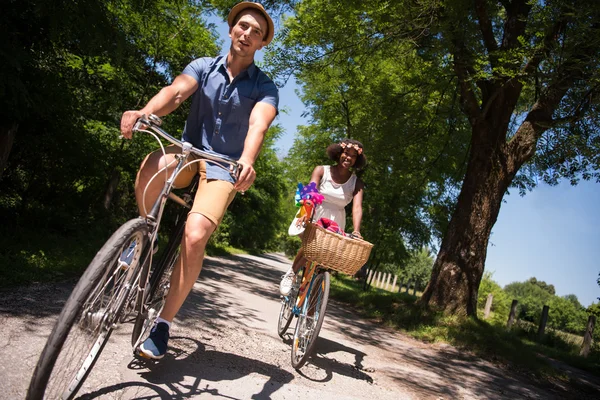 Joven pareja multiétnica teniendo un paseo en bicicleta en la naturaleza — Foto de Stock