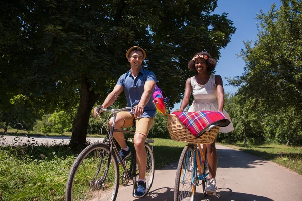 Unga multietniskt par att ha en cykel rida i naturen — Stockfoto