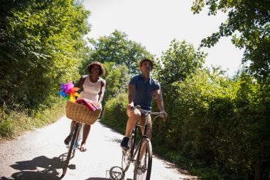 Bisiklete sahip genç çok ırklı çift doğada binmek