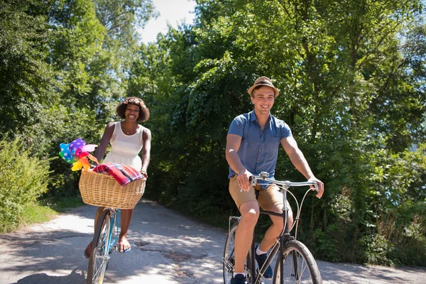 Jovem casal multiétnico ter um passeio de bicicleta na natureza — Fotografia de Stock