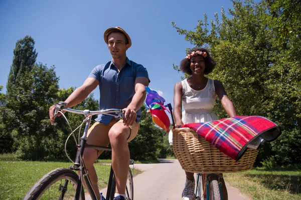 Jovem casal multiétnico ter um passeio de bicicleta na natureza — Fotografia de Stock