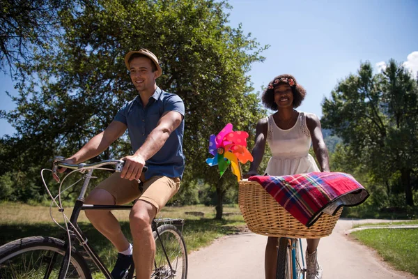 Unga multietniskt par att ha en cykel rida i naturen — Stockfoto