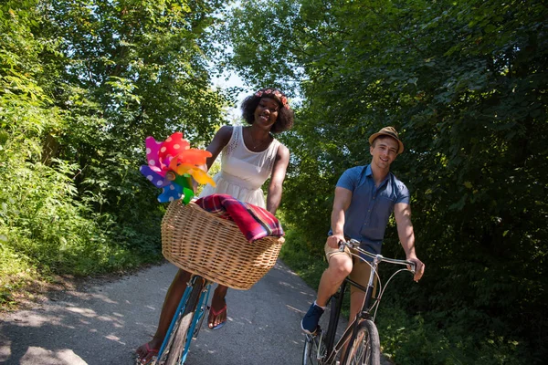 Jovem casal multiétnico ter um passeio de bicicleta na natureza — Fotografia de Stock