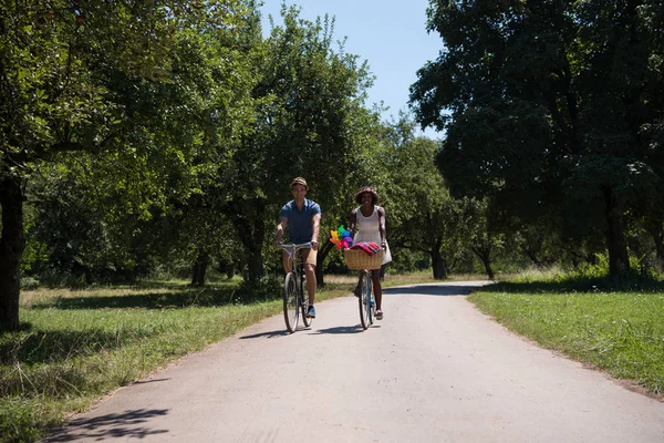 Joven pareja multiétnica teniendo un paseo en bicicleta en la naturaleza — Foto de Stock