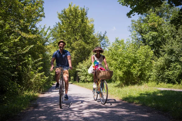 Unga multietniskt par att ha en cykel rida i naturen — Stockfoto