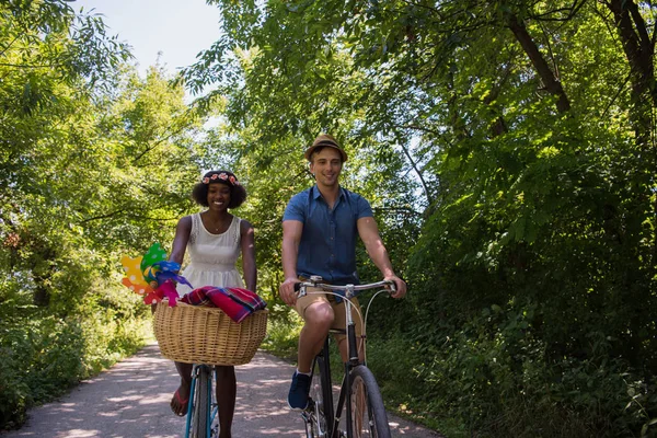 Jovem casal multiétnico ter um passeio de bicicleta na natureza — Fotografia de Stock