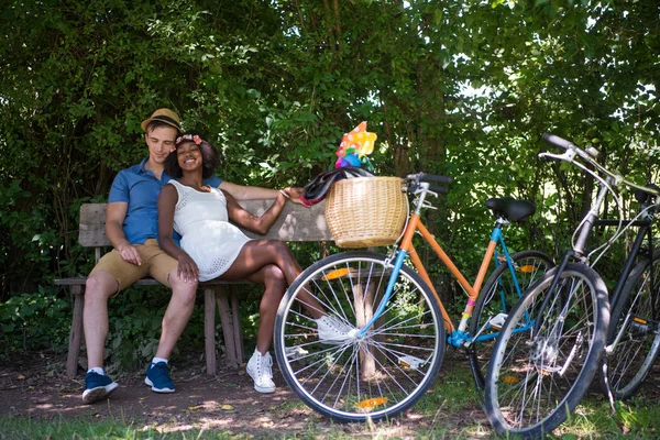 Jovem casal multiétnico ter um passeio de bicicleta na natureza — Fotografia de Stock