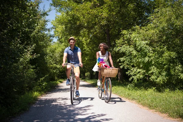 Joven pareja multiétnica teniendo un paseo en bicicleta en la naturaleza — Foto de Stock