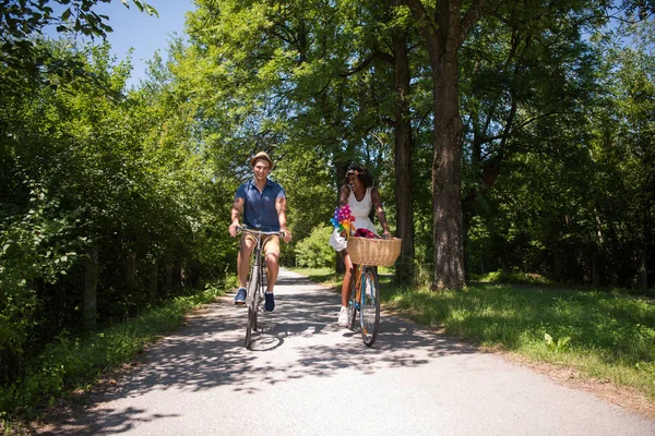 Unga multietniskt par att ha en cykel rida i naturen — Stockfoto