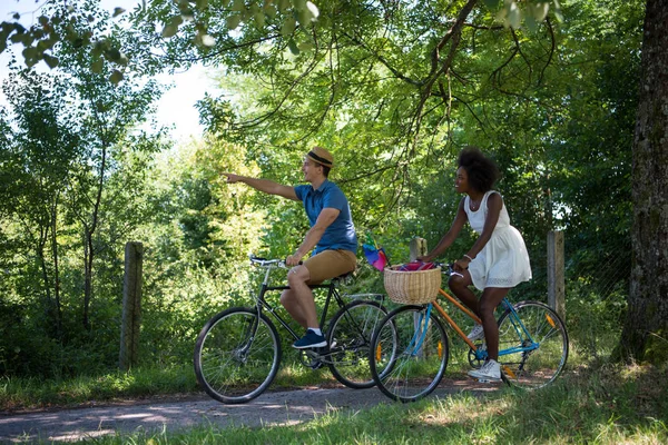 Jeune couple multiethnique faisant une balade à vélo dans la nature — Photo