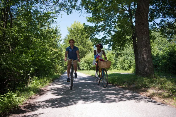 Unga multietniskt par att ha en cykel rida i naturen — Stockfoto