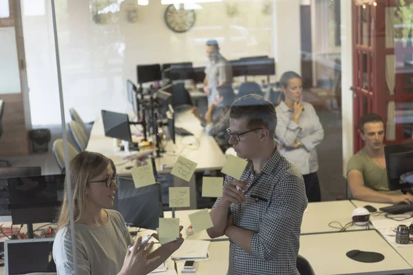 Jong koppel bij moderne kantoor interieur schrijven c HTING stickers — Stockfoto