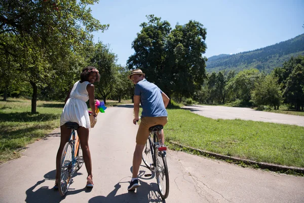 うれしそうな自転車を持っている若いカップルが自然に乗る — ストック写真