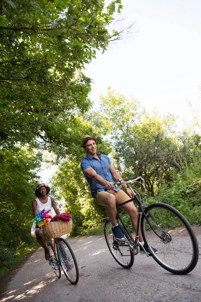 Jong koppel met vrolijke fiets rijden in de natuur — Stockfoto