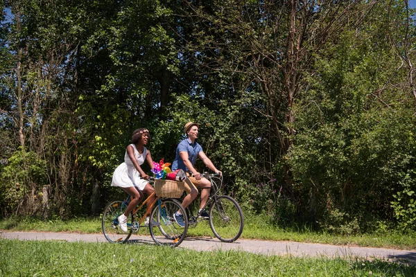 うれしそうな自転車を持っている若いカップルが自然に乗る — ストック写真