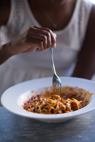 Seorang wanita muda Afrika-Amerika makan pasta — Stok Foto